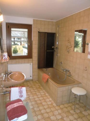 a bathroom with a tub and a sink at Ferienwohnungen Federleicht in Titisee-Neustadt