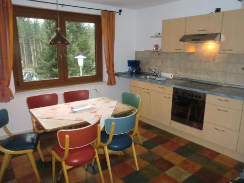a kitchen with a table and chairs and a table at Ferienwohnungen Federleicht in Titisee-Neustadt