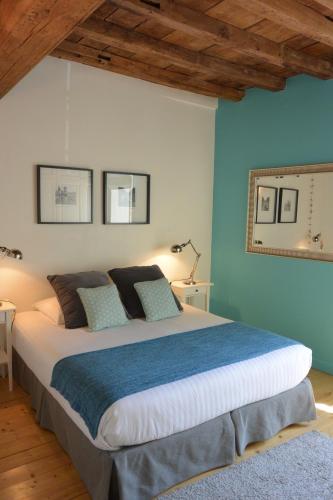 a bedroom with a large bed with blue walls at Le Clos Millot in Beaune