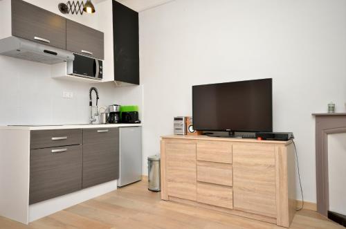 une cuisine avec une télévision à écran plat sur une armoire en bois dans l'établissement One bedroom apartment Palais des festivals, à Cannes