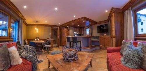 a living room with red couches and a table at Villa Haidacher Relax & Lifestyle Apartments in Zell am Ziller