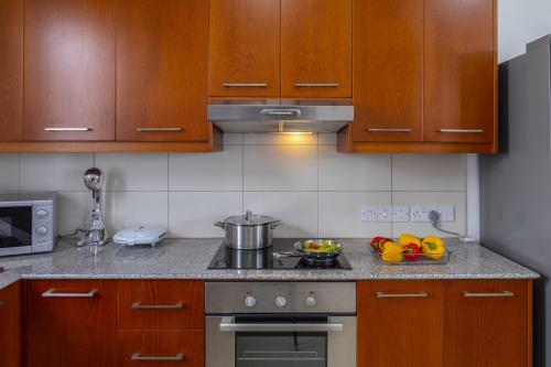 a kitchen with wooden cabinets and a stove top oven at Faros BeachFront Villa in Pervolia