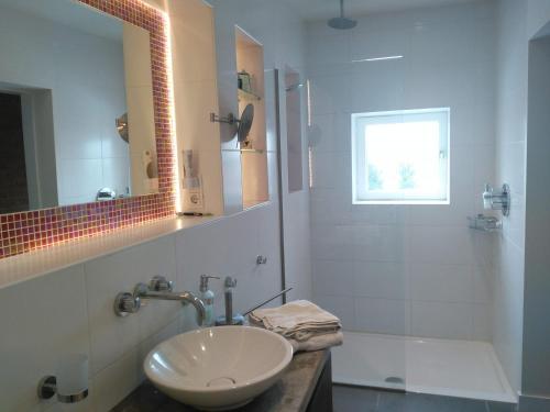 a white bathroom with a sink and a mirror at Hotel De Wilde Kriek in Valkenburg