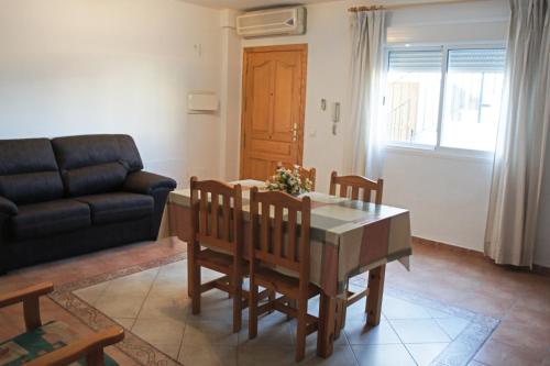 un soggiorno con tavolo, sedie e divano di APARTAMENTOS ALBANTA ad Alhama de Almería