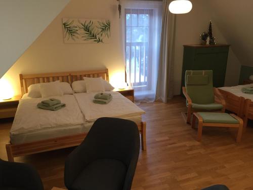 a bedroom with a bed and two chairs and a table at Vila Apalucha49 Čeladná - 12 osob in Čeladná