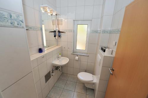 a white bathroom with a toilet and a sink at Casa-Gorma at the beach, Apartment 121 in Zavala
