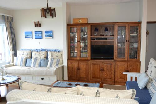a living room with a couch and a tv at Nine-ohh Skuitbaai in Eersterivierstrand