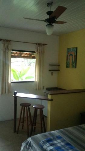 a bedroom with a bar with stools and a window at Pousada Embaubas in Serra do Cipo