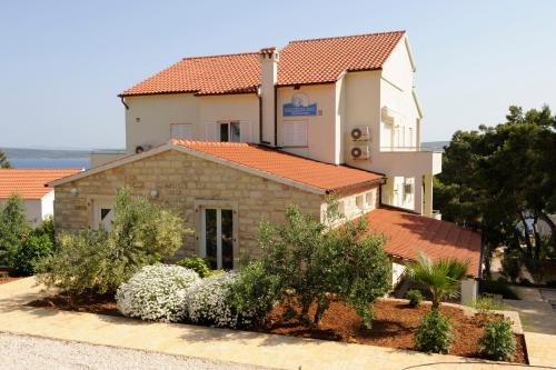 un edificio con techo naranja y algunos arbustos en Nautilus-Bay Apartments - Apartments 112 - Casa Gorma, en Zavala