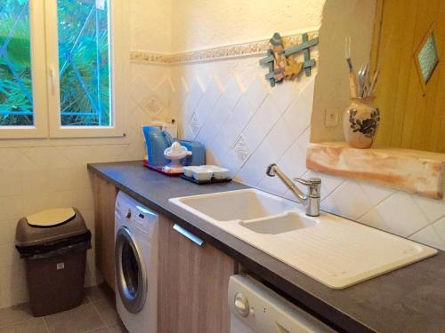 a kitchen with a sink and a washing machine at San Ciprianu in Porto-Vecchio