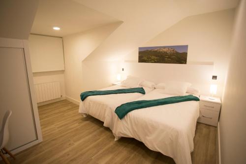 a bedroom with two beds and a painting on the wall at Canto Encaramado in Gibaja
