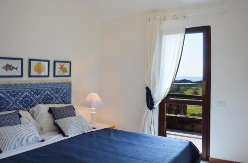 a bedroom with a blue bed and a window at CASE BELVEDERE in Chia