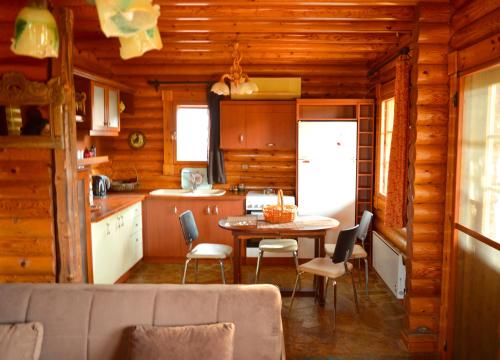 a kitchen and dining room with a table in a cabin at Ξύλινο σπίτι (κορμόσπιτο, μεζονέτα, EcoHouse) in Nea Artaki