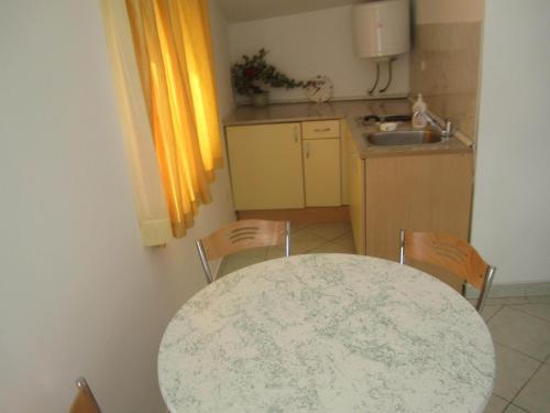 a kitchen with a table and chairs and a sink at Apartments Krešić TIHA LUKA in Neum