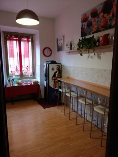 een keuken met een bar met krukken en een koelkast bij Domus Appia 154 B&B in Rome