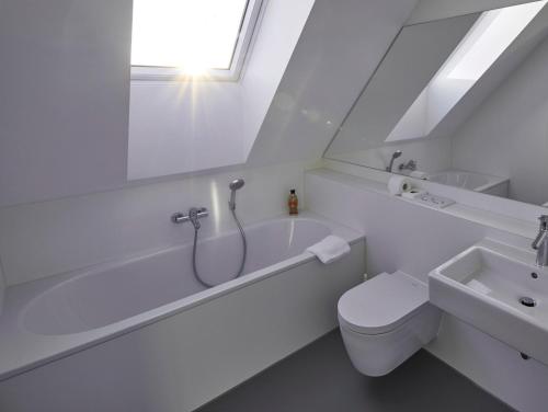 a white bathroom with a toilet and a sink at Radhotel am Gleis in Radolfzell am Bodensee