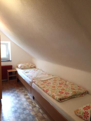 a room with two beds sitting next to a wall at Youth Hostel Nika in Kranjska Gora