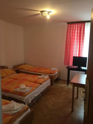 a room with two beds and a desk with a computer at Youth Hostel Nika in Kranjska Gora