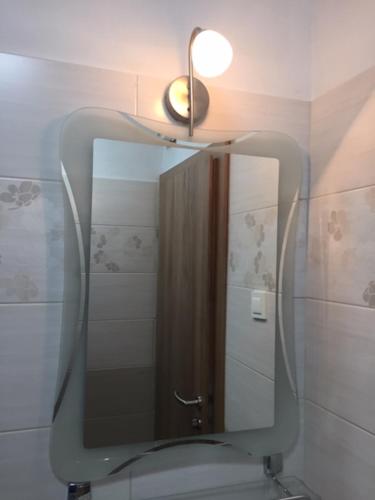 a bathroom with a mirror over a toilet with a light at Youth Hostel Nika in Kranjska Gora