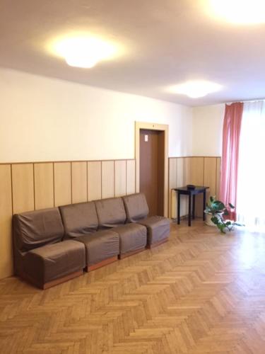 a living room with a brown couch in a room at Youth Hostel Nika in Kranjska Gora