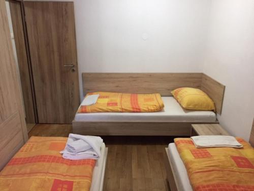 two beds in a small room with twoperate beds at Youth Hostel Nika in Kranjska Gora