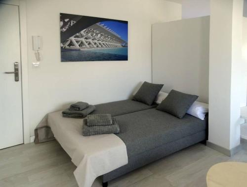 Bett in einem Zimmer mit einem Bild an der Wand in der Unterkunft ÁTICO PTA 13 EN EL CENTRO DE VALENCIA VT-45727-T in Valencia