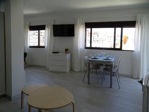 een eetkamer met een tafel, stoelen en ramen bij ÁTICO PTA 13 EN EL CENTRO DE VALENCIA VT-45727-T in Valencia