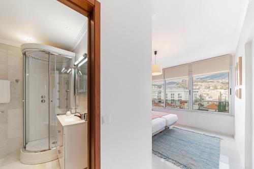 a bathroom with a shower and a window at Arriaga I by An Island Apart in Funchal