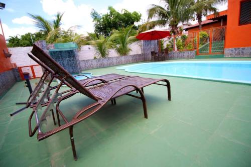 a bench sitting next to a swimming pool at Pousada Sol Nascente in Olímpia