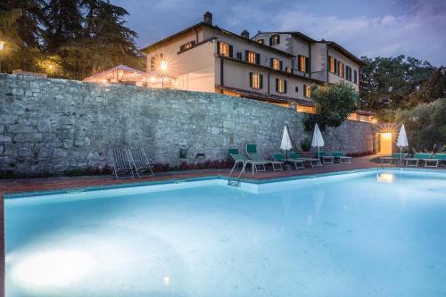 una grande piscina di fronte a un edificio di Hotel Villa Casalecchi a Castellina in Chianti