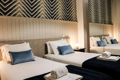 a hotel room with two beds with hats on them at Santo da Casa / Sc apartments in Porto