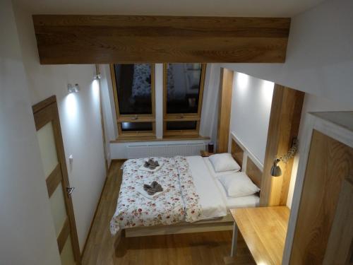 a small bedroom with a bed and a window at Apartamenty Pod Różami in Rabka-Zdrój