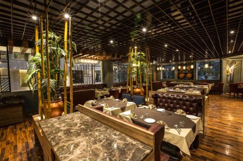 um restaurante com mesas e cadeiras num quarto em Sterling Palm Bliss - Rishikesh em Rishikesh