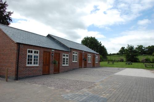 a red brick building with white windows in a park at The Royal Oak in Loughborough