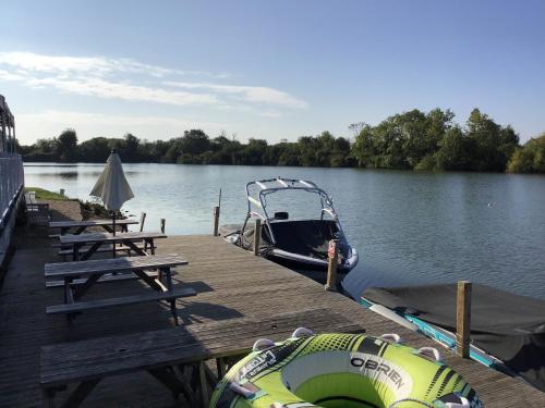 a boat is docked at a dock on a lake at Grange Lodge in South Cerney