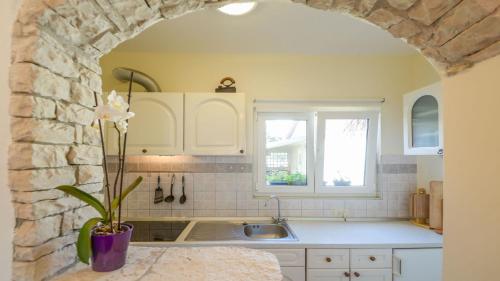 a kitchen with a sink and a stone wall at Apartment Medulin in Medulin
