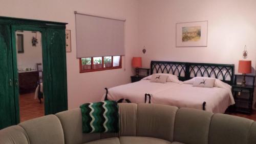 una sala de estar con dos camas y un sofá en Agroturismo la finka, en Los Quiles