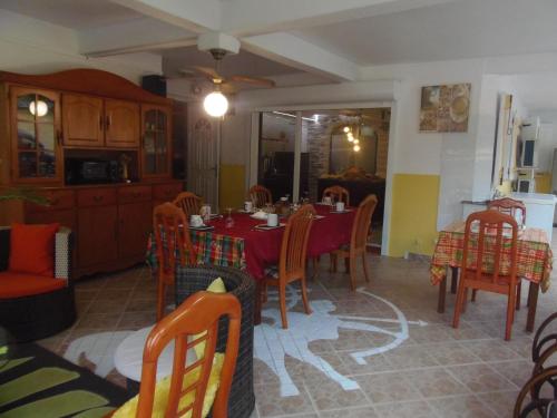 a dining room with a red table and chairs at Villa Mancina in Capesterre-Belle-Eau