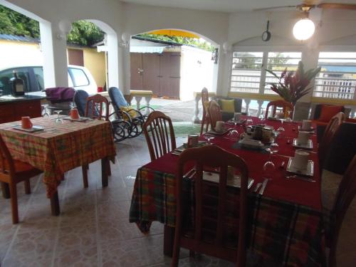 a restaurant with tables and chairs in a room at Villa Mancina in Capesterre-Belle-Eau
