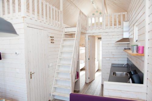 a tiny house with a ladder and a sink at Surf en beach strandhuisjes in Katwijk