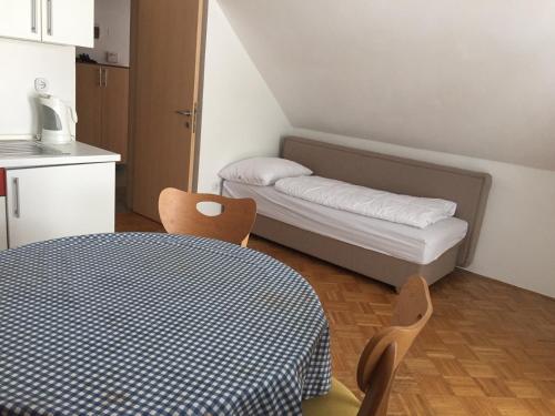 a small room with a bed and a table and chairs at Apartmaji Kranjska Gora in Kranjska Gora