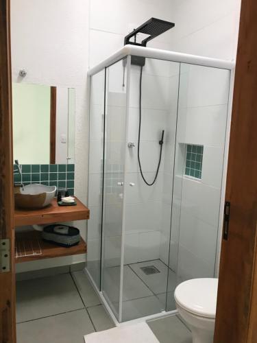 uma casa de banho com um chuveiro, um WC e um lavatório. em Nai'a Suites em Ubatuba