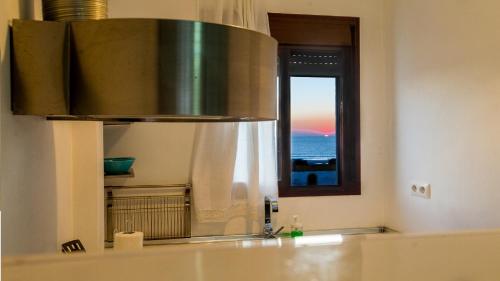 La salle de bains est pourvue d'un lavabo, d'un miroir et d'une fenêtre. dans l'établissement ÁTICO BELLA VISTA, à Tarifa