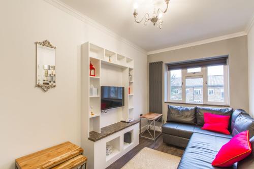 ein Wohnzimmer mit einem Sofa und einem TV in der Unterkunft Luxury London Apartment in London