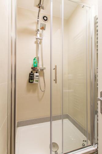 a shower with a glass door in a bathroom at Luxury London Apartment in London