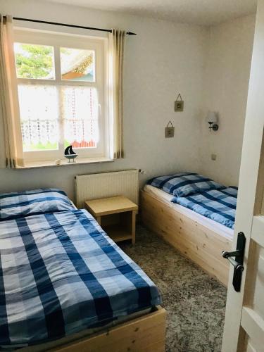 two beds in a room with a window at "Kombüse" by Ferienhaus Strandgut in Born