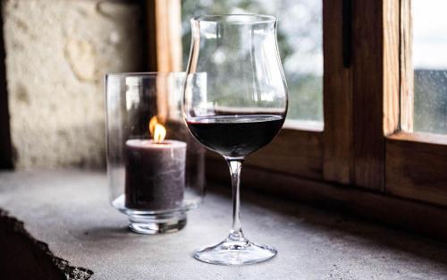 a glass of wine and a candle on a window at Hotel Villa Casalecchi in Castellina in Chianti