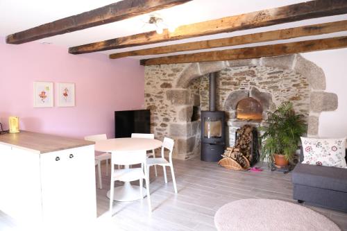 a kitchen and living room with a stone fireplace at Le Four à Pain in Leynhac