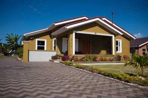 a yellow house with a driveway at Villa Sophia in Mammee Bay