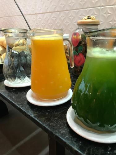 Dos jarras de vidrio de jugo de naranja sobre una mesa en Shallom Hotel, en Balneário Camboriú